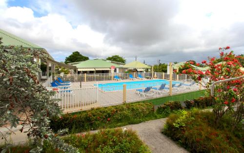 a pool at a resort with blue chairs and flowers at Village de Bragelogne in Saint-François