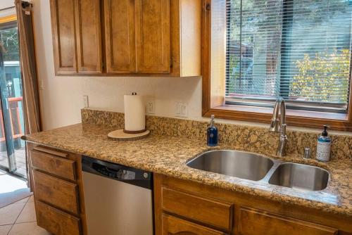 um balcão de cozinha com um lavatório e uma janela em The Lilac Lodge, The Ultimate Getaway! em Big Bear City