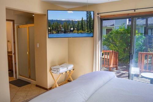 um quarto com uma cama e uma televisão na parede em The Lilac Lodge, The Ultimate Getaway! em Big Bear City