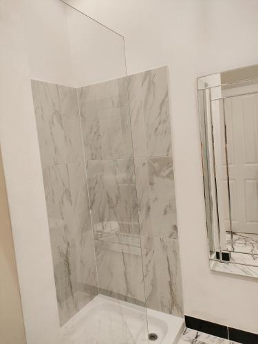 a shower with a glass door in a bathroom at Versailles in Nottingham