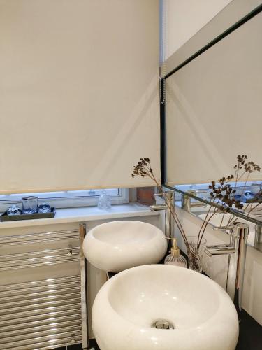 uma casa de banho com um lavatório branco e um espelho. em Versailles em Nottingham