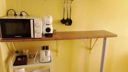 a counter with a microwave and some utensils at Sueña Paco in Torremolinos