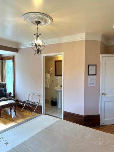 a bedroom with a bed and a chandelier at Le Chateau du Lac in Magog-Orford