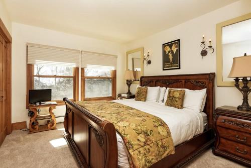 a bedroom with a large bed and a television at Durant Unit D3, Condo with Floor-to-Ceiling Windows, Fireplace, and more in Aspen