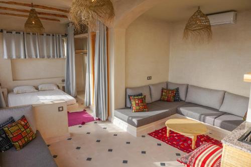 un soggiorno con divano e letto di SurfAppart Morocco a Tamraght Ouzdar