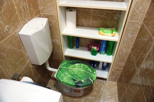 a bathroom with a toilet and a green trash can at Central City Apartment in Belgrade