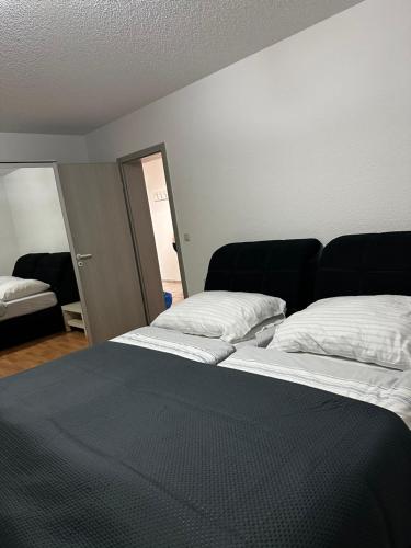 1 Schlafzimmer mit 2 Betten und weißen Kissen in der Unterkunft Ferienwohnung in Erzingen Klettgau in Klettgau