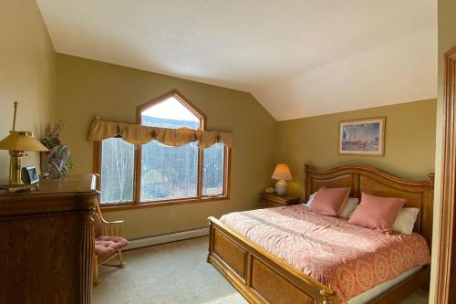 a bedroom with a bed and a desk and windows at Large 5 bedroom Bretton Woods Townhome 1 gig WiFi in Bretton Woods