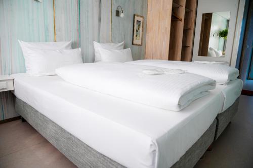 two large white beds in a room with a mirror at Abalon Hotel ideal in Stuttgart