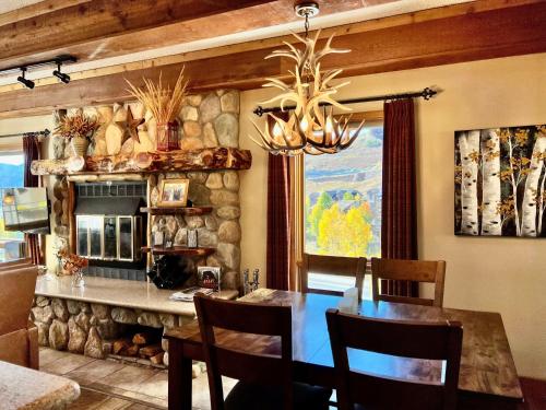 comedor con mesa y pared de piedra en Spacious & Cozy Condo With Wood Fireplace condo, en Crested Butte