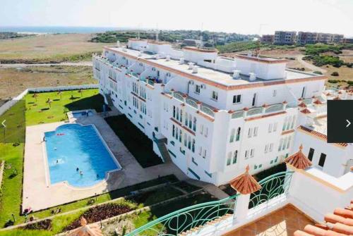 an aerial view of a large white building with a swimming pool at appartement de vacances achakar avec plage&piscine in Tangier