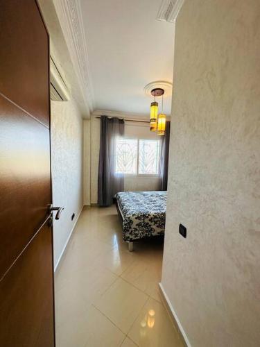 a hallway with a room with a bed and a window at appartement de vacances achakar avec plage&piscine in Tangier