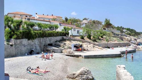 Grupa ludzi na plaży w wodzie w obiekcie Apartment Silo 3 w mieście Šilo
