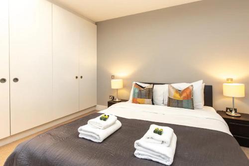 a bedroom with a large bed with towels on it at London City 1 Bed with Roof Terrace in London