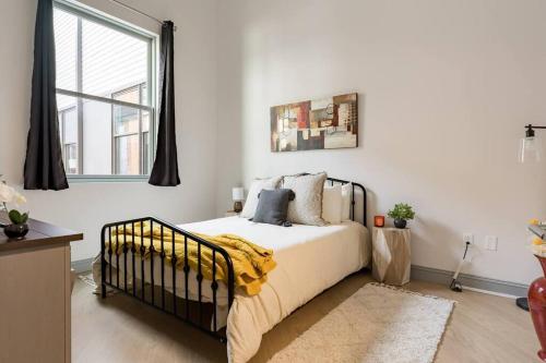 a bedroom with a bed with a yellow blanket on it at Gorgeous Condo in the Heart of DT Birmingham! in Birmingham