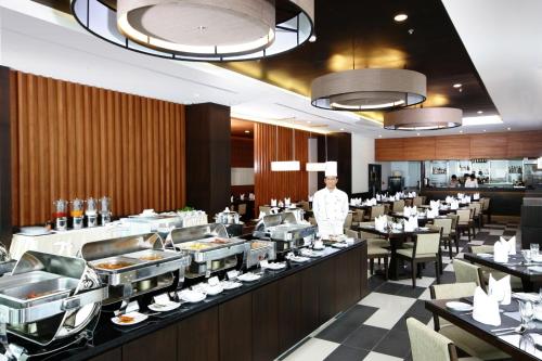 a restaurant with a chef standing in front of a buffet at Kantary Hotel Ayutthaya in Phra Nakhon Si Ayutthaya