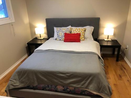 - une chambre avec un grand lit et 2 tables de chevet dans l'établissement 4 bed Cozy Basement Apartment with Massage, Gym, Billiards Facilities, à Whitby
