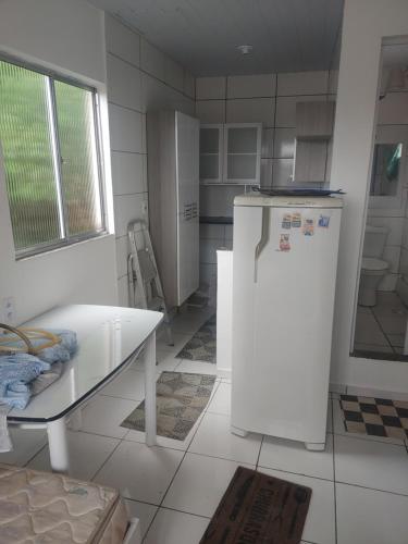 uma cozinha com um frigorífico e uma mesa em Quitinete no Rio de Janeiro