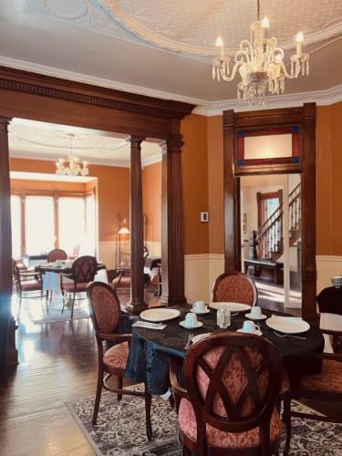 a dining room with a table and chairs and a chandelier at Le Chateau du Lac in Magog-Orford