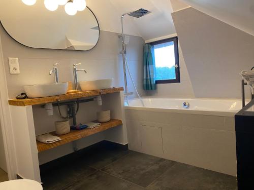 une salle de bain avec un lavabo, une baignoire et un miroir dans l'établissement Maison Normande avec piscine à 10 min d'Honfleur, à Saint-Pierre-du-Val