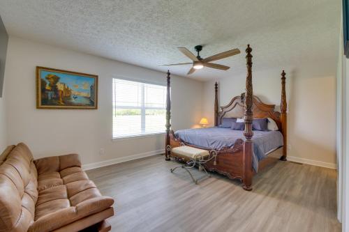 a bedroom with a bed and a couch and a ceiling fan at Port Clinton Retreat with Lake Access and Dock! in Port Clinton