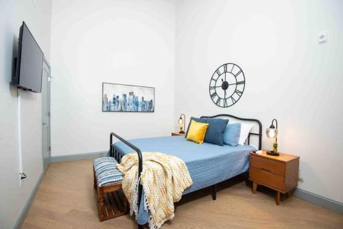 a bedroom with a bed and a clock on the wall at Lovely Condo in Downtown Birmingham in Birmingham