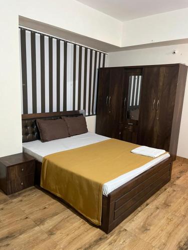 a bedroom with a large bed with a wooden headboard at Royal Palm's Private 1 BHK Garden Apartment in Pune