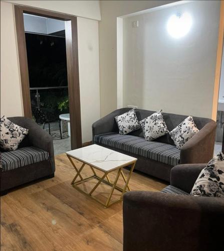 uma sala de estar com dois sofás e uma mesa de centro em Royal Palm's Private 1 BHK Garden Apartment em Pune