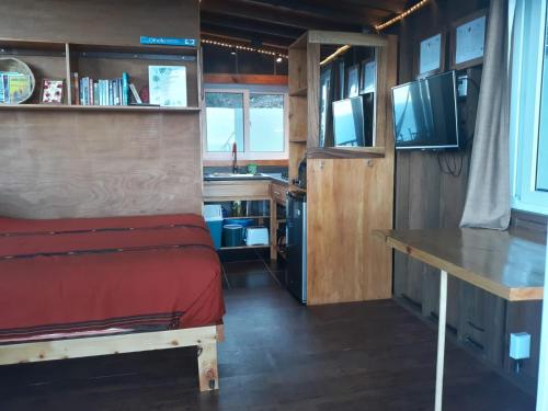 a bedroom with a bed and a desk and a sink at Refugio del Volcan Casitas in San Pedro La Laguna