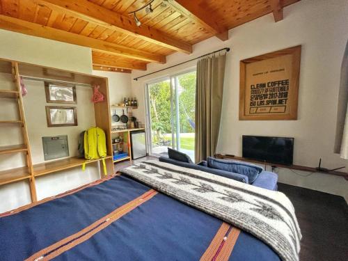 a bedroom with a large bed and a large window at Refugio del Volcan Casitas in San Pedro La Laguna