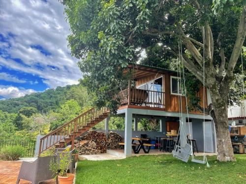 a tree house with a balcony and a swing at Refugio del Volcan Casitas in San Pedro La Laguna