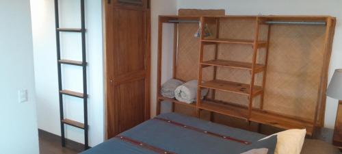 a room with a bed and a wooden book shelf at Refugio del Volcan Casitas in San Pedro La Laguna