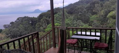 a balcony with a view of the ocean and mountains at Refugio del Volcan Casitas in San Pedro La Laguna