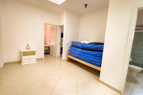 - une chambre avec un lit et une couette bleue dans l'établissement Casa charmosa com piscina em rua tranquila, à São Sebastião