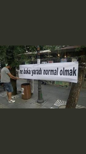 a man holding a sign that reads meida vaughan normal oink at Bandırma ev in Bandırma
