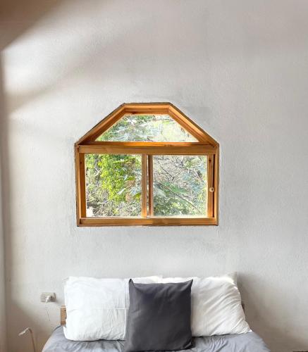 een raam boven een bed in een kamer bij EB5 Escape-Contemporary Stay, San Marcos La Laguna #1 in San Marcos La Laguna