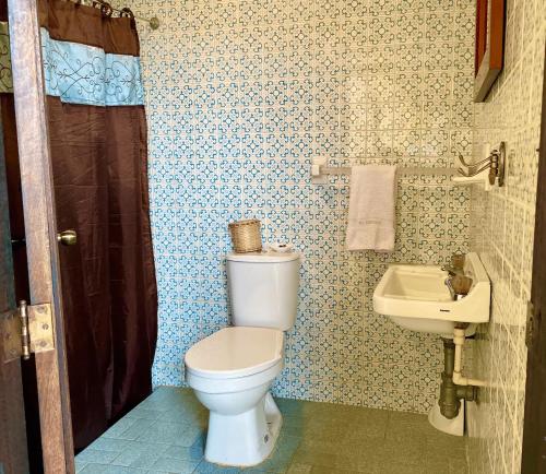 a bathroom with a toilet and a sink at Mi Refugio in Guasca