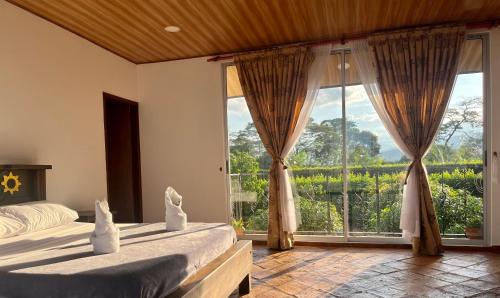 a bedroom with two beds and a large window at Casa Campestre Denis in Guamal