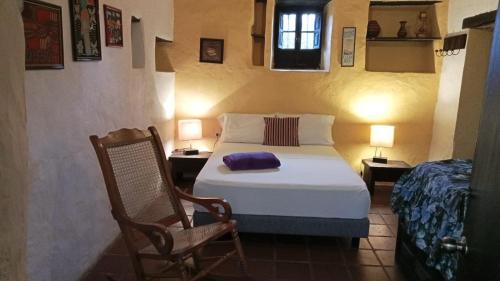 een slaapkamer met een bed en een stoel in een kamer bij Mi Refugio in Guasca