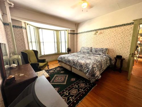 a bedroom with a bed and a desk and a chair at Arundel Mansions Hotel in New Westminster