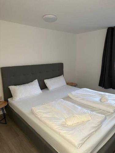 a large bed with white sheets and pillows on it at PrimeBnb Bad Salzungen in Bad Salzungen