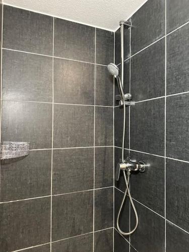 a bathroom with a shower with a hose at PrimeBnb Bad Salzungen in Bad Salzungen