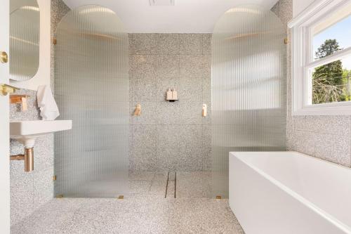 a white bathroom with a tub and a sink at Blue Mountains Bliss in Leura
