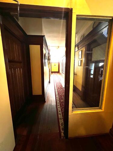 an empty hallway with a door and a mirror at Arundel Mansions Hotel in New Westminster