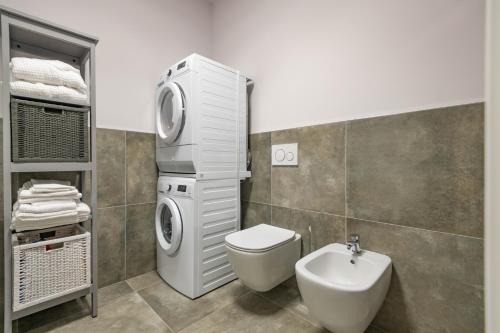 uma casa de banho com uma máquina de lavar roupa e um lavatório em Alloggio moderno in centro paese em Corneliano d'Alba