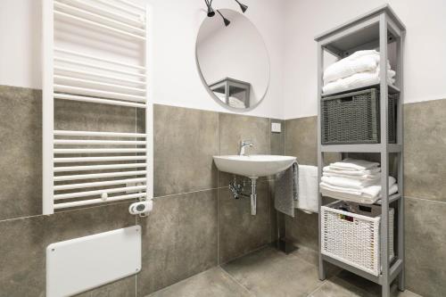 uma casa de banho com um lavatório e um espelho em Alloggio moderno in centro paese em Corneliano d'Alba