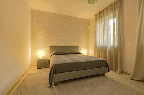 um quarto com uma cama grande e uma janela em Alloggio moderno in centro paese em Corneliano d'Alba