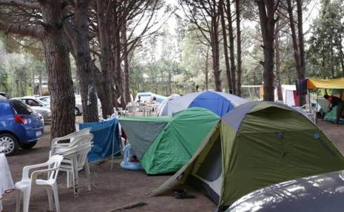 un gruppo di tende in un parcheggio con alberi di Camping çuğra a Erdek
