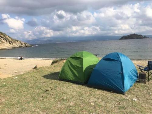 two tents sitting on a beach next to the ocean at Camping çuğra in Erdek