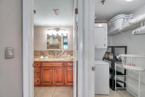 a kitchen with wooden cabinets and a white refrigerator at Pet-friendly 2-bed Condo With Amazing Waterfront Views in Clearwater Beach